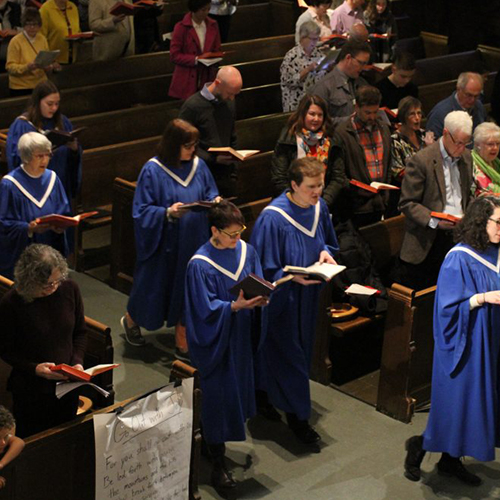 Choir walking down the aisle with song books open